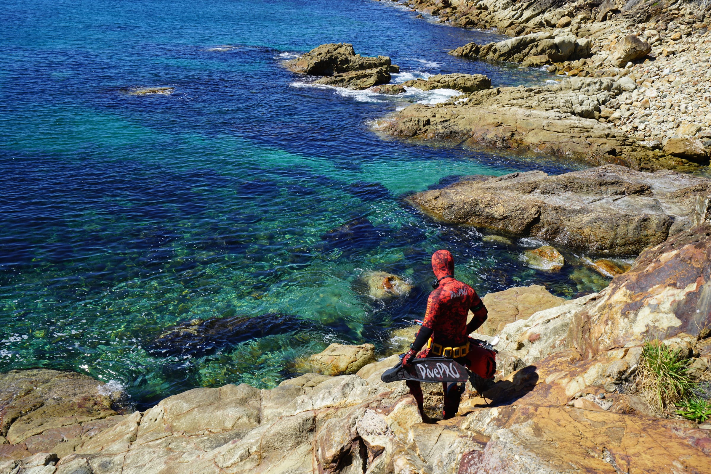 DivePRO diver entering rocky coastal water
